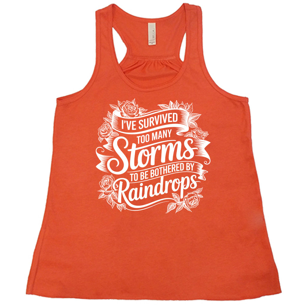 Coral Flowy Tank, with wording I've Survived Too Many Storms to be Bothered by Raindrops, banners and flowers