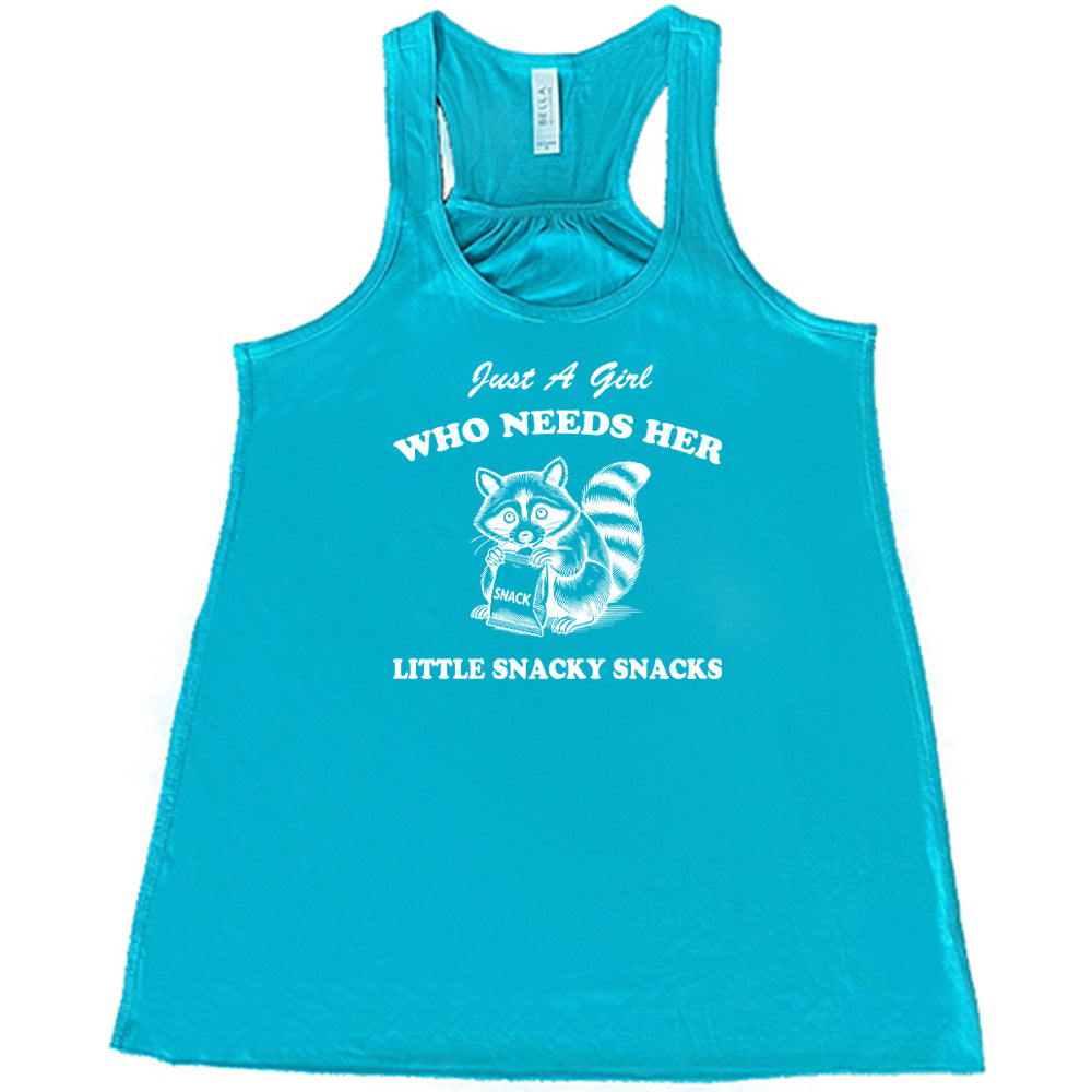 Teal colored flowy tank with a raccoon holding a snack graphic on it that says "Just a Girl Who Needs Her Little Snacky Snacks" 