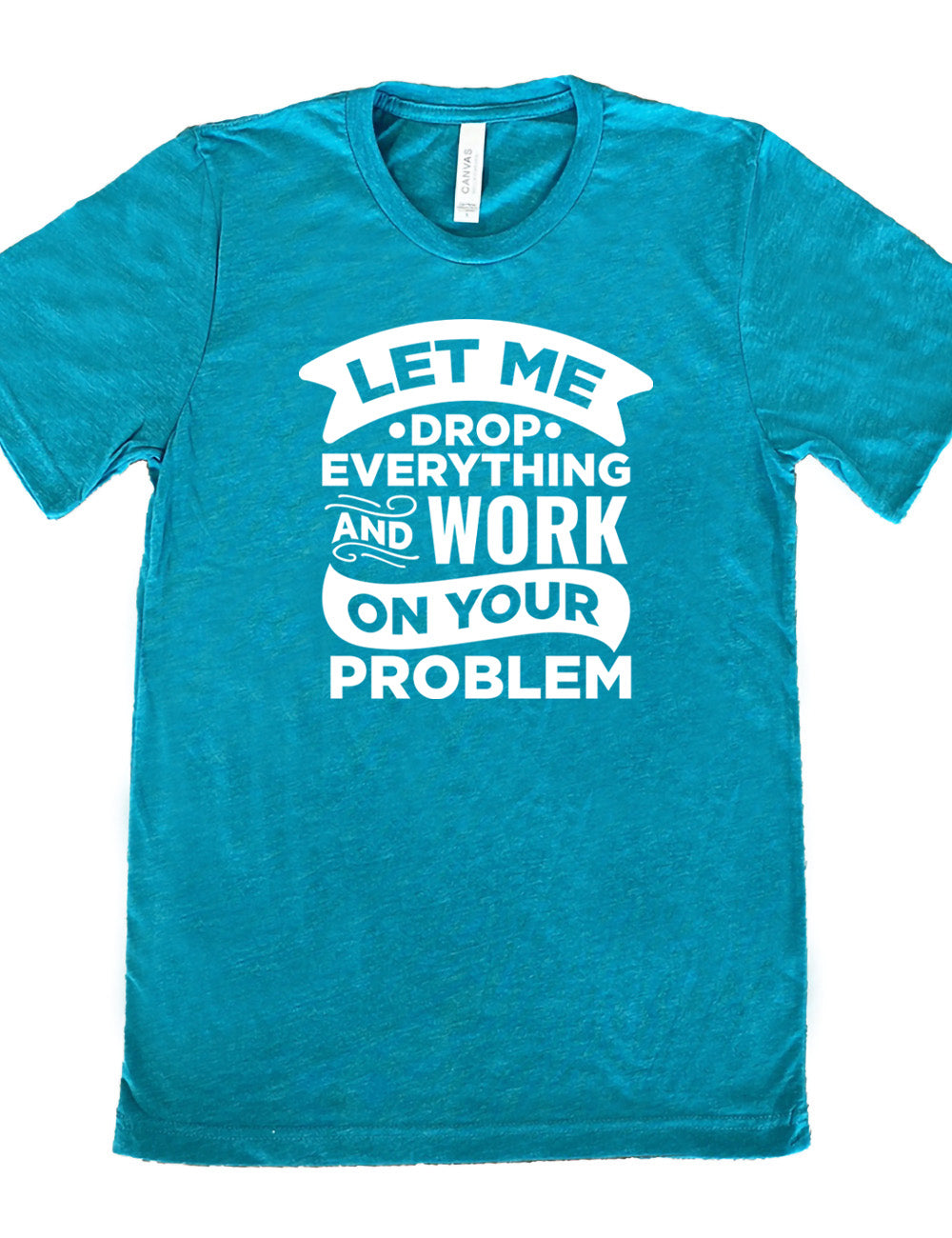 teal unisex tee with the words, some of them bannered or embellished, saying "Let me drop everything and work on your problem" 