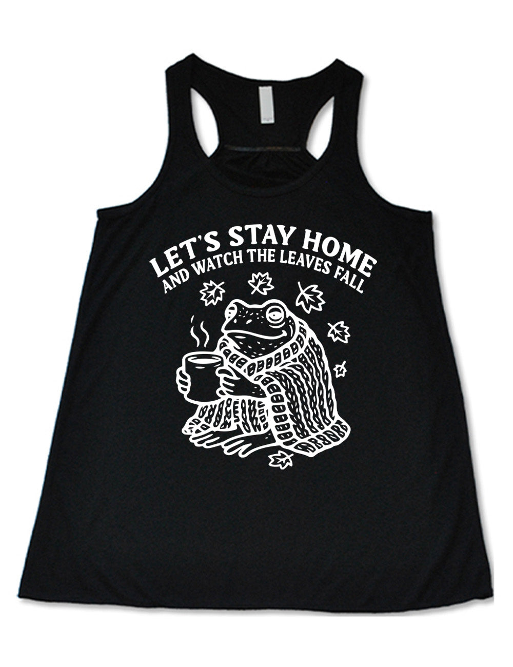 black flowy racerback tank with the words "let's stay home and watch the  leaves fall" on it, and the graphic underneath of a frog, wrapped in a blanket, holding a mug of steaming beverage, with five leaves arching over it
