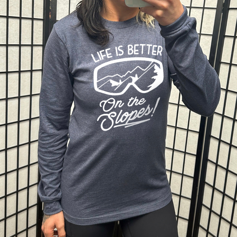 Heather navy long sleeve with the words "Life is better on the slopes!" with the image of snow goggles and a reflection of the slopes in them