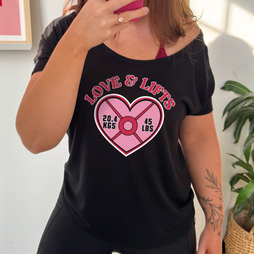 black slouchy shirt with the words "love & lifts" on it, and graphics underneath of a heart with "20.4 kgs" and "45 lbs" inside it