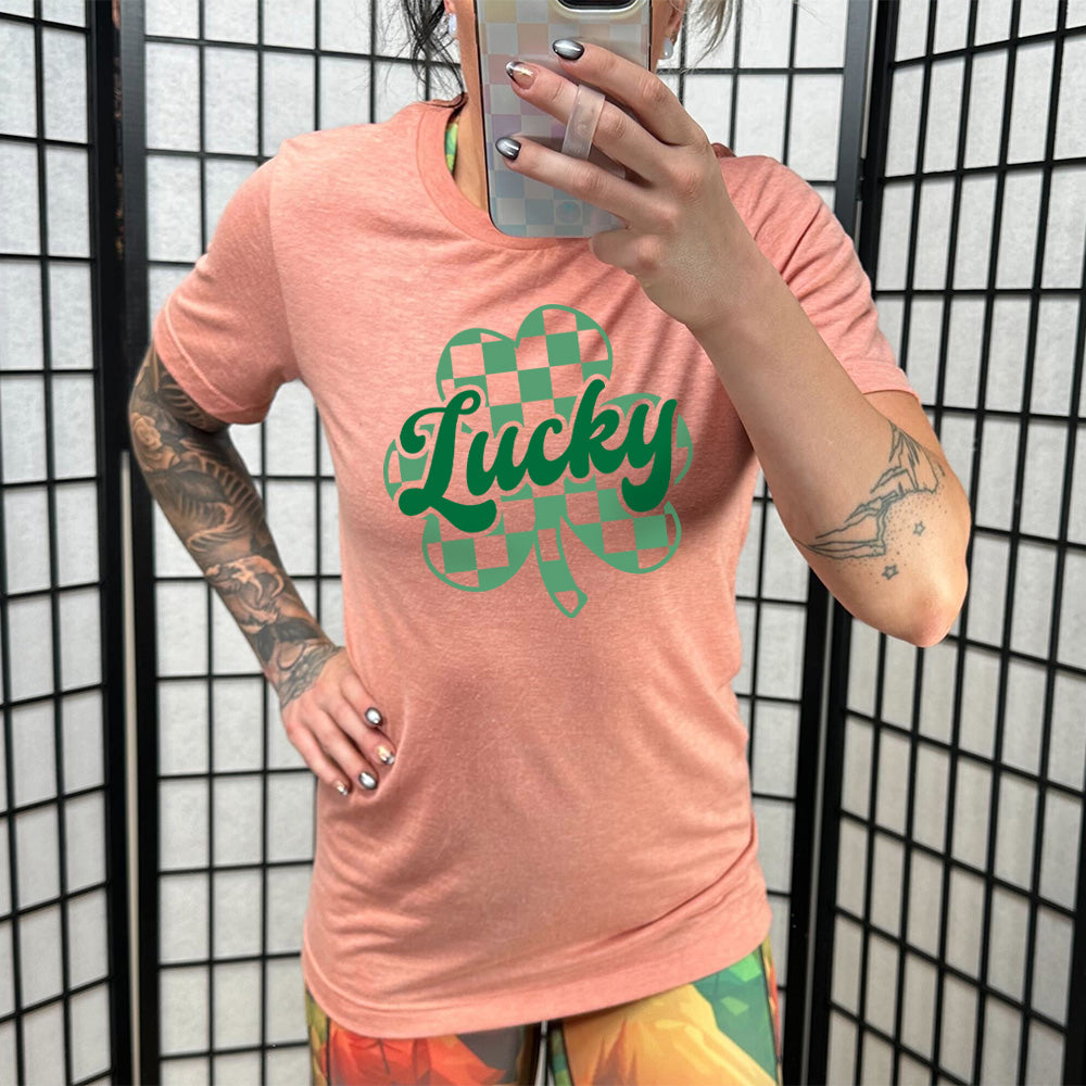 coral shirt with a checkered shamrock graphic on it