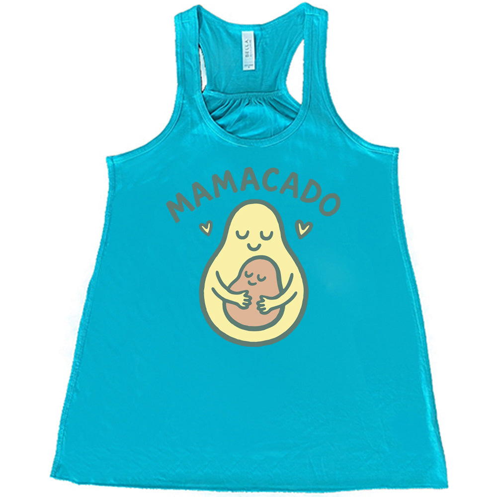 teal racerback flowy tank with the words "mamacado" on it, with the graphic of an avocado, peacefully smiling, with arms, holding her smiling baby (the color and placement of the avocado pit - but in the shape of an avocado), with a little heart on either side 
