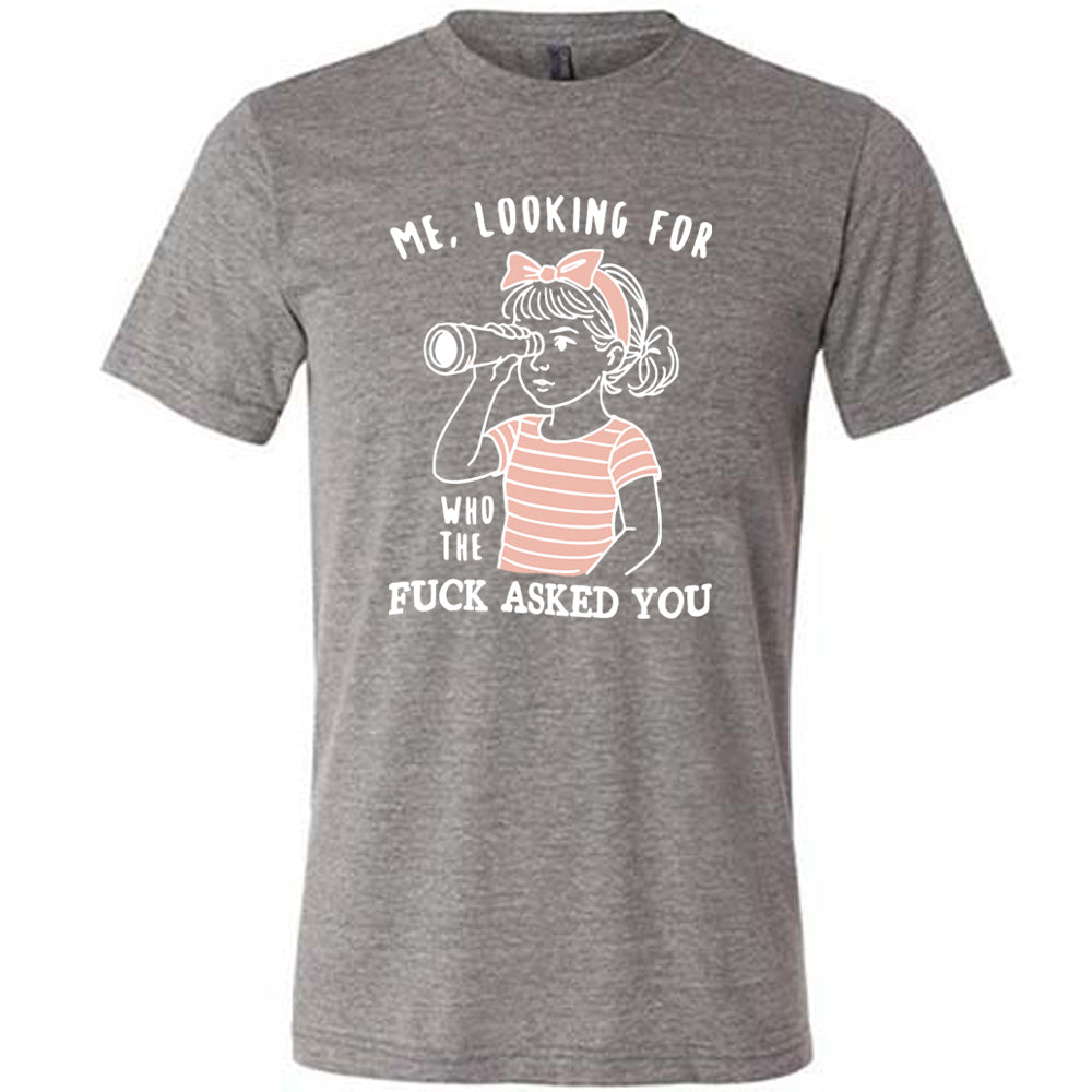 grey unisex tee with the graphic of a young girl, wearing a striped pink shirt and a pink bowed headband and looking through a telescope, and the words "me, looking for who the fuck asked you" on it