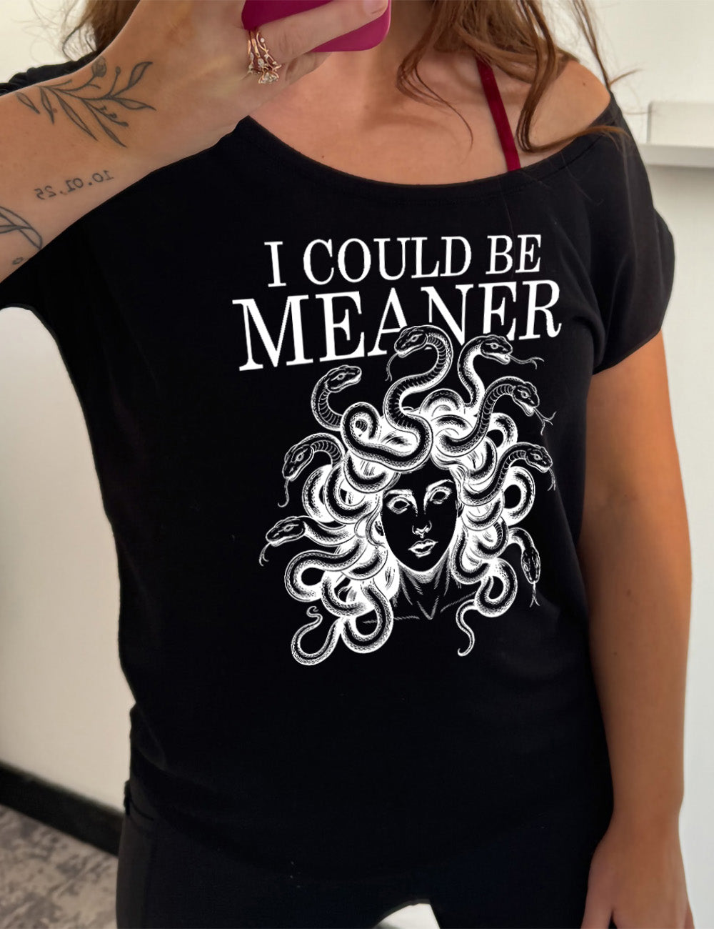 black slouchy tee with the graphic of snake-haired medusa, with the words above it saying "I could be meaner"