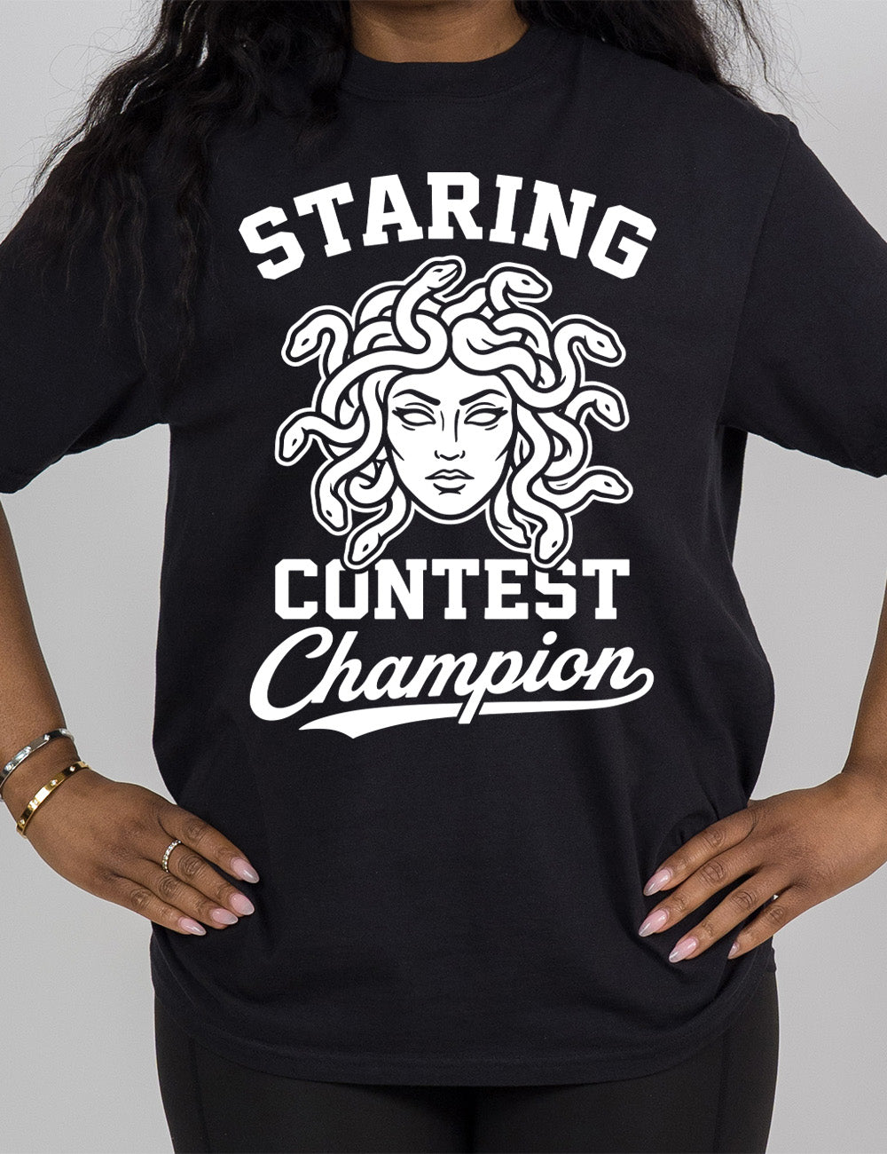 black modern tee with words surrounding the graphic of medusa's head saying "staring contest champion"