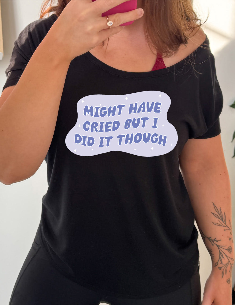 black slouchy tee with the words, within a blobby shape with a few stars, saying "might have cried but I did it though"