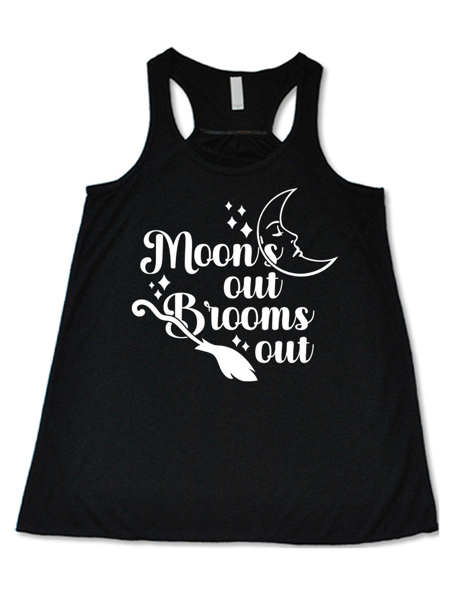 black flowy racerback tank with the words "moon's out brooms out" on it, with the line graphic of a crescent moon, with a sleeping face, and the graphic of a broom, and a few scattered stars