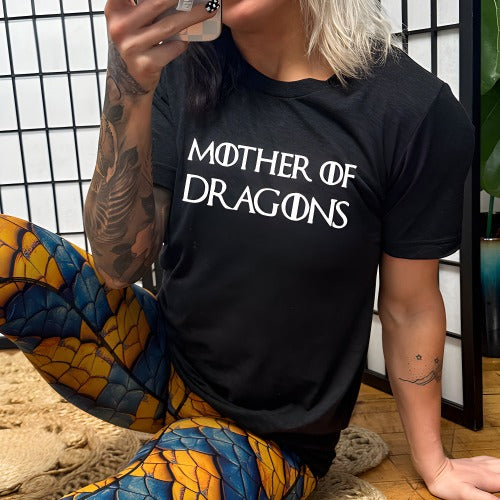 model wearing a black unisex shirt with the saying "mother of dragons" on it in white