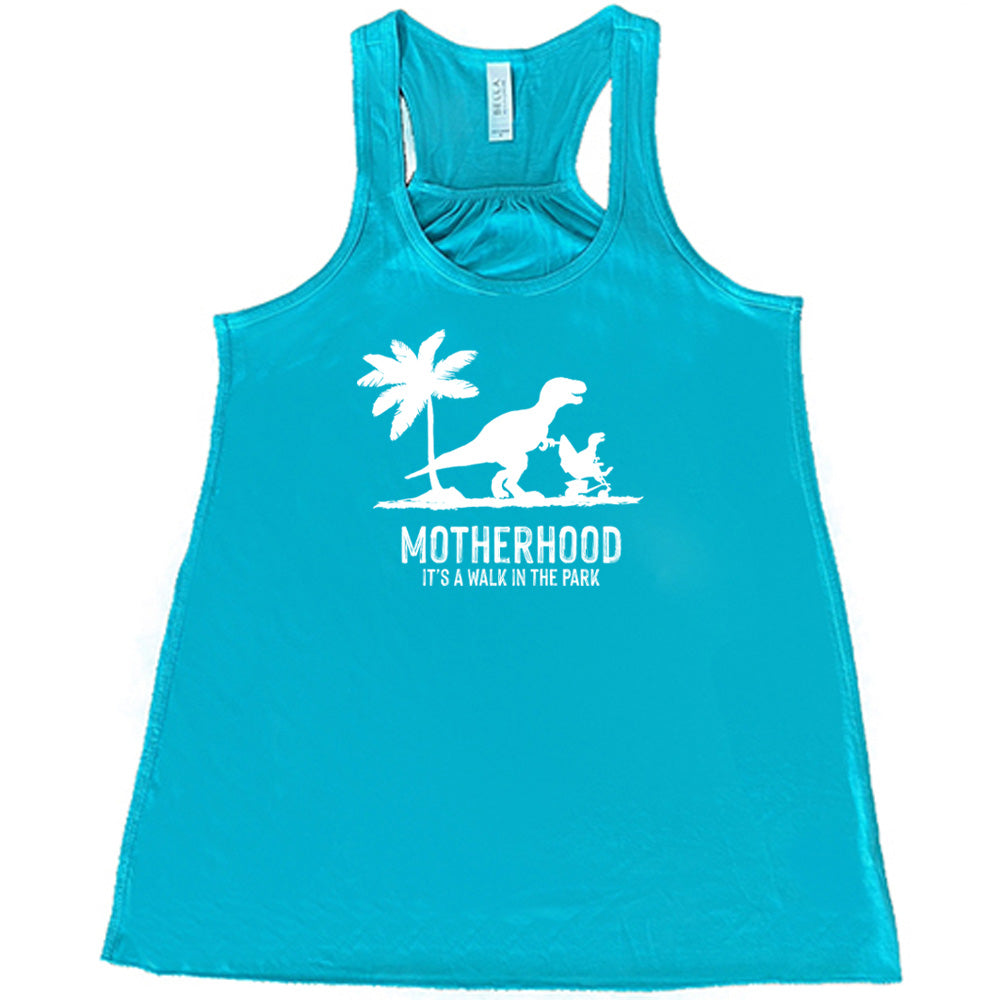 Teal colored flowy tank with a mother and child dinosaur graphic on it that says "Motherhood, Its a Walk in the Park" 