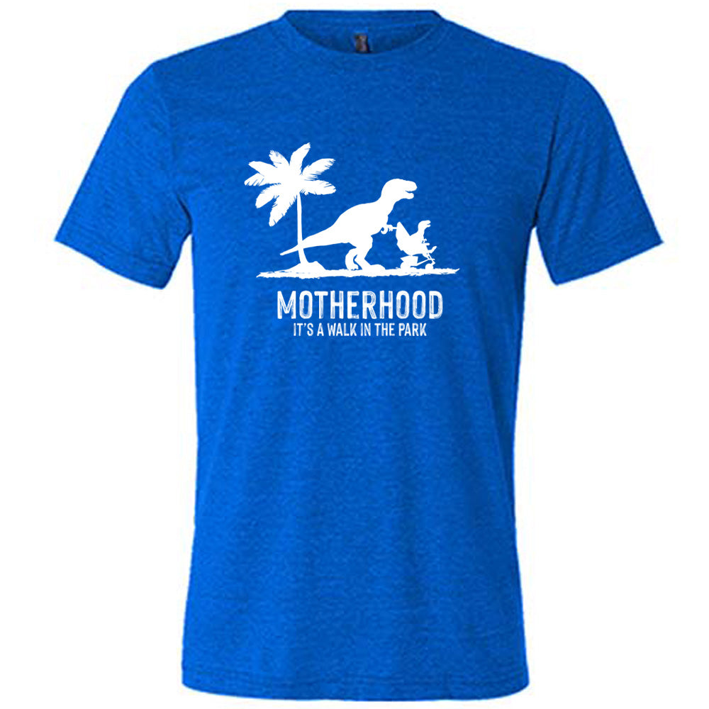 Blue colored shirt with a mother and child dinosaur graphic on it that says "Motherhood, Its a Walk in the Park" 
