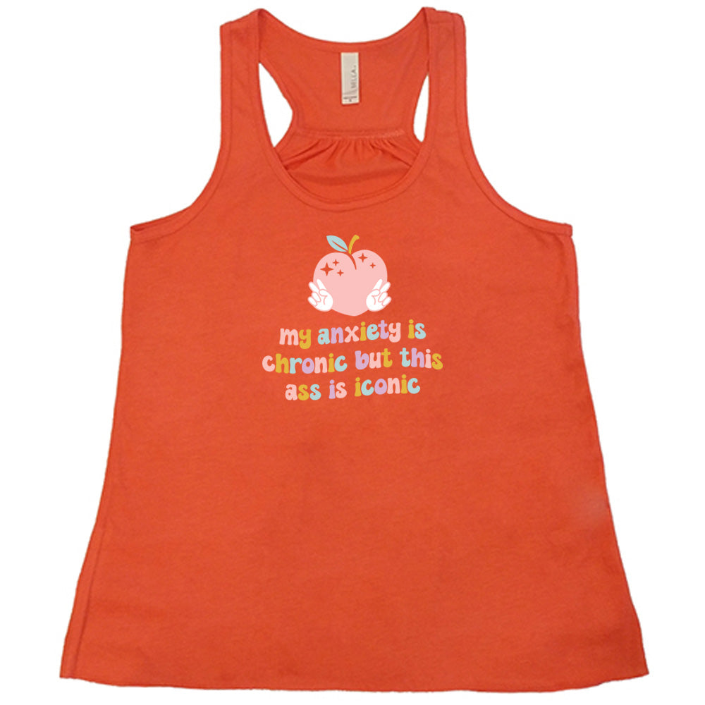 Coral colored flowy tank with a peach and peace signs graphic on it that says "My Anxiety Is Chronic But This Ass Is Iconic" 