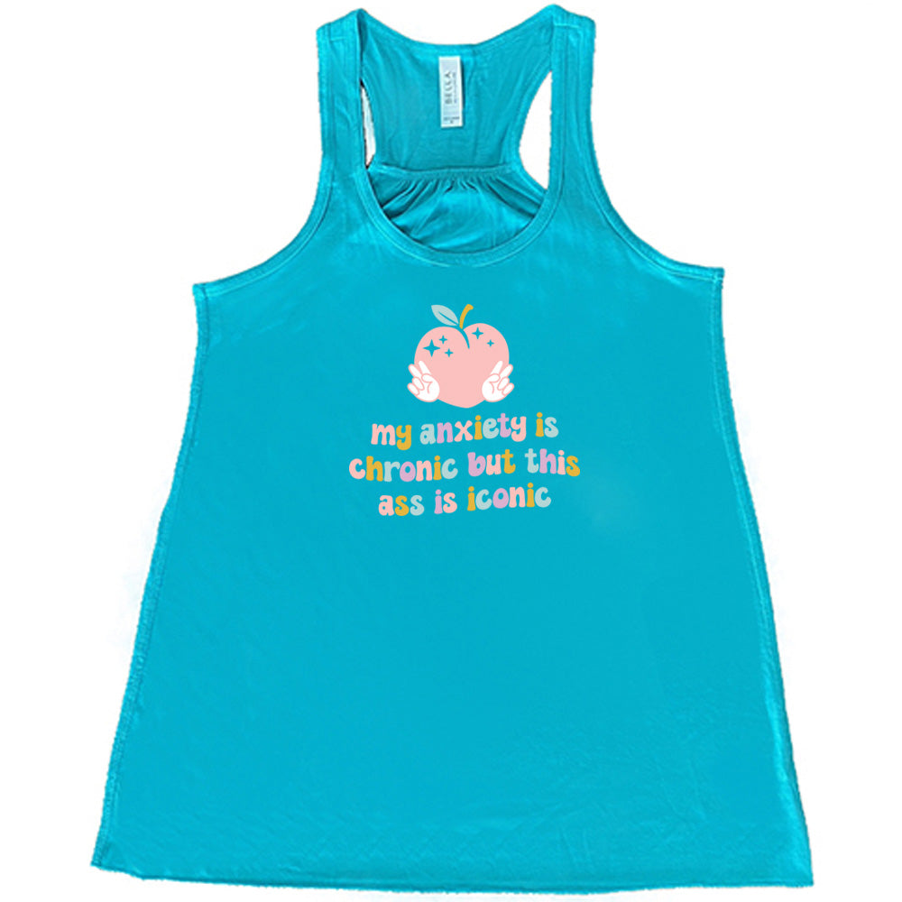Teal colored flowy tank with a peach and peace signs graphic on it that says "My Anxiety Is Chronic But This Ass Is Iconic" 