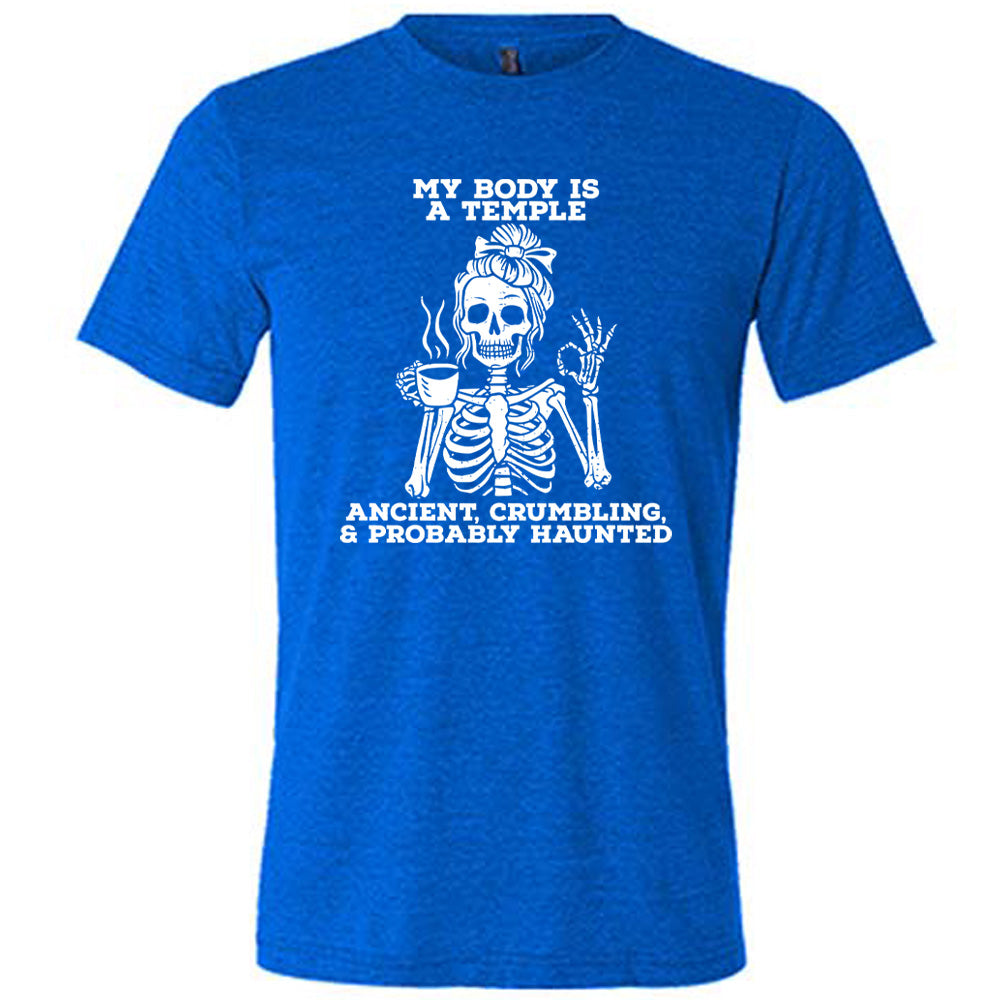 blue unisex tee with the words "My Body Is a Temple Ancient, Crumbling, & Probably Haunted" on it, with the graphic of a skeleton with its hair in a bow, with one hand holding steaming coffee, and the other giving the OK symbol