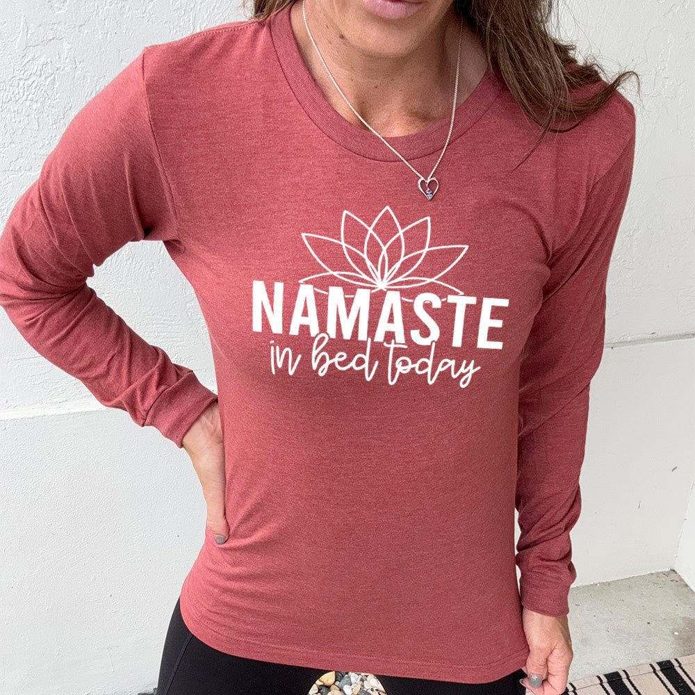 Heather clay  long sleeve shirt with the words "Namaste in bed today" with a line art of a lotus flower above it