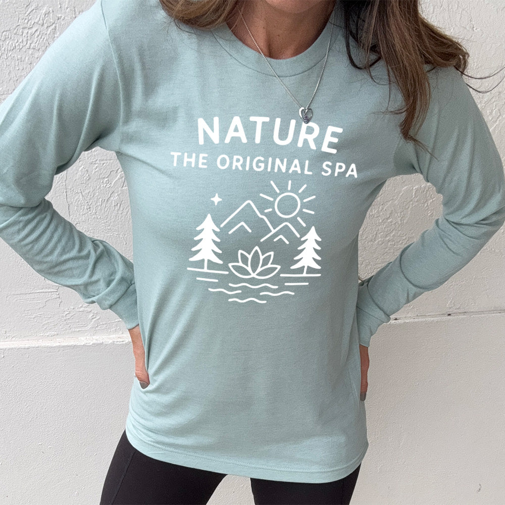 heather dusty blue long sleeve with the words "nature the original spa" on it, with the mostly line-art graphic of the sun, mountains, trees, a single star, water, and a lotus flower