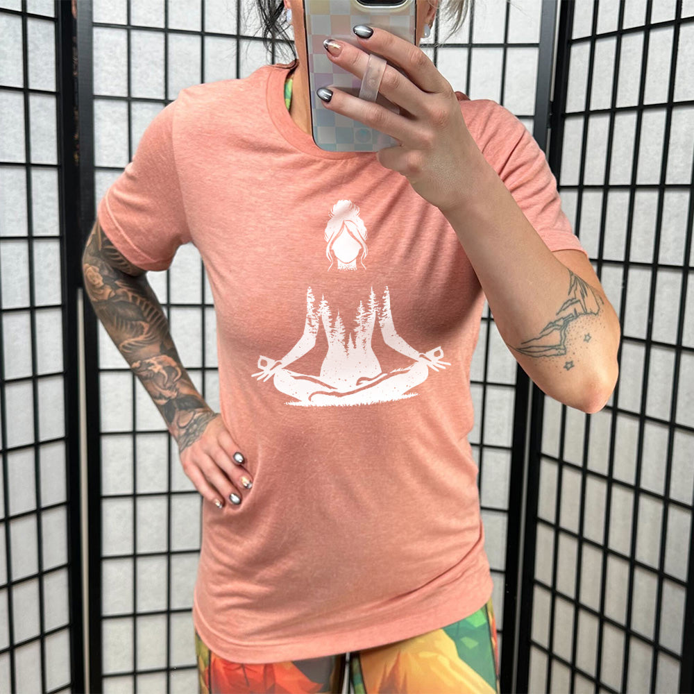 Sunset unisex tee with the graphic of a woman doing a yoga pose, with her shoulders to waist being the silhouette of a forest  