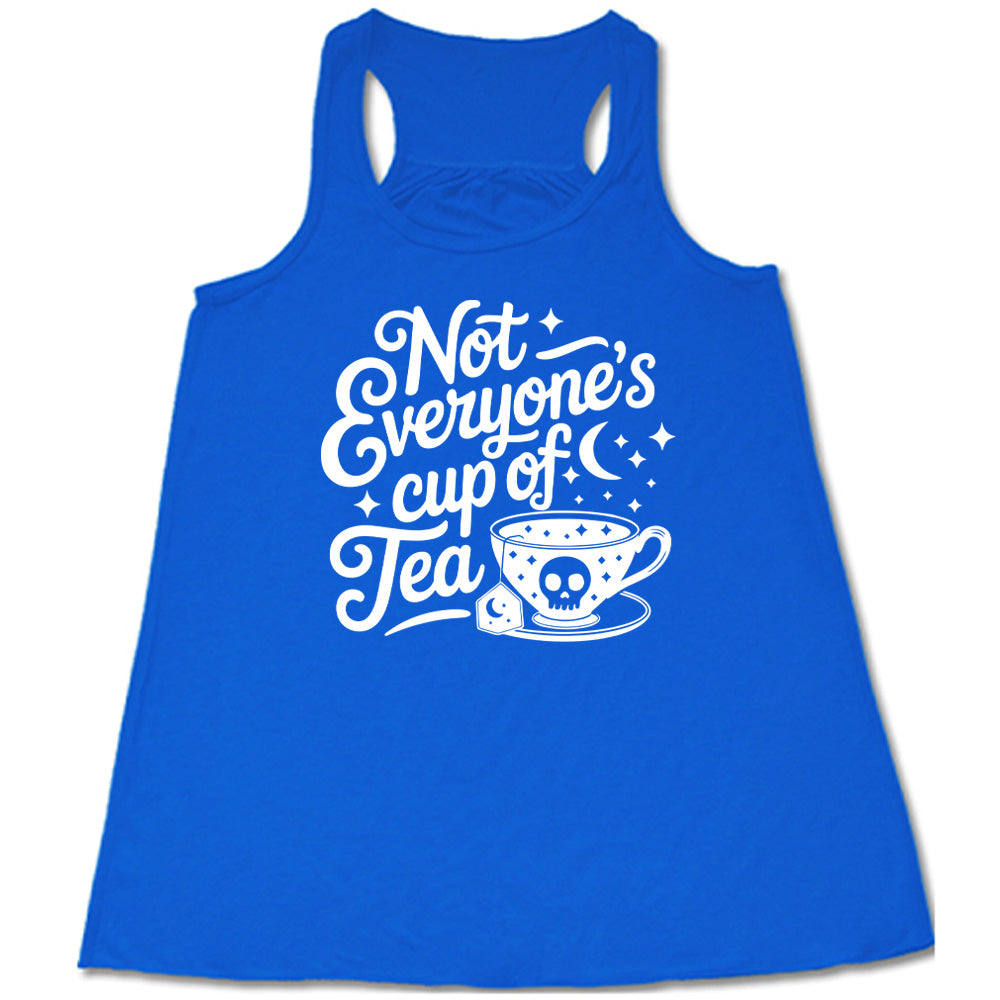 blue flowy tank with the words "not everyone's cup of a tea" in a cursive font, with the graphics of a moon and little stars, and a tea cup with a skull on it with stars and the tea bag has a moon on it