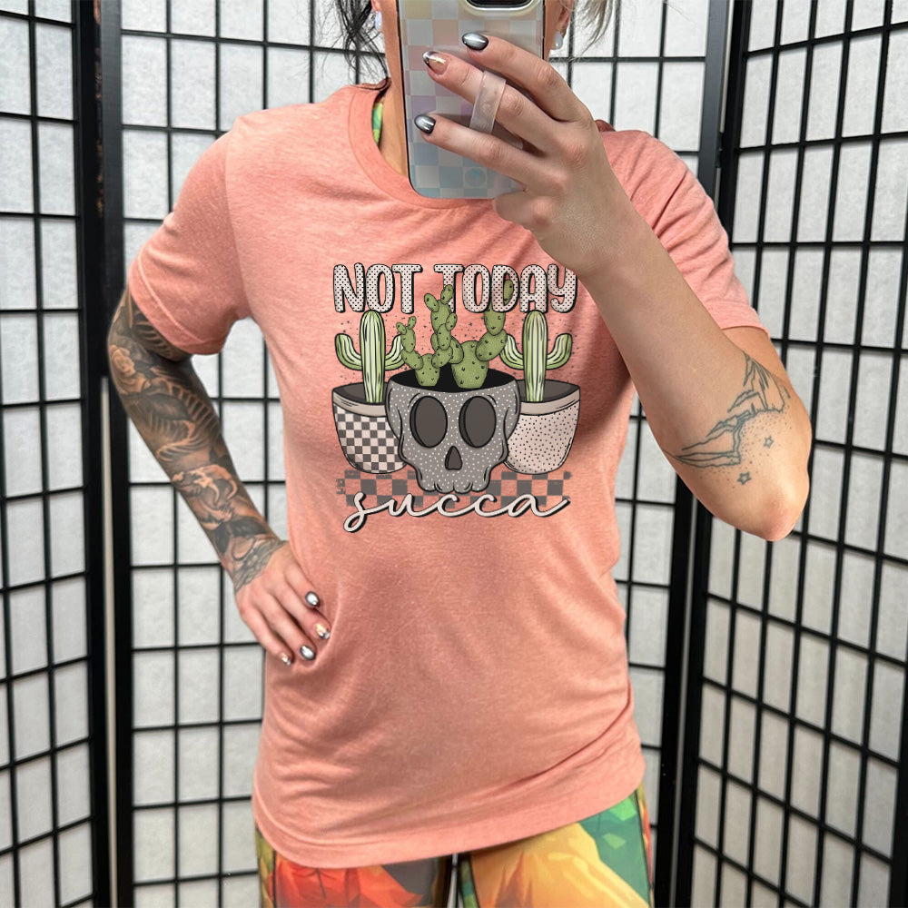 Model wearing sunset colored shirt with skull shaped pot and succulents graphic on it that says "Not Today Succa" 