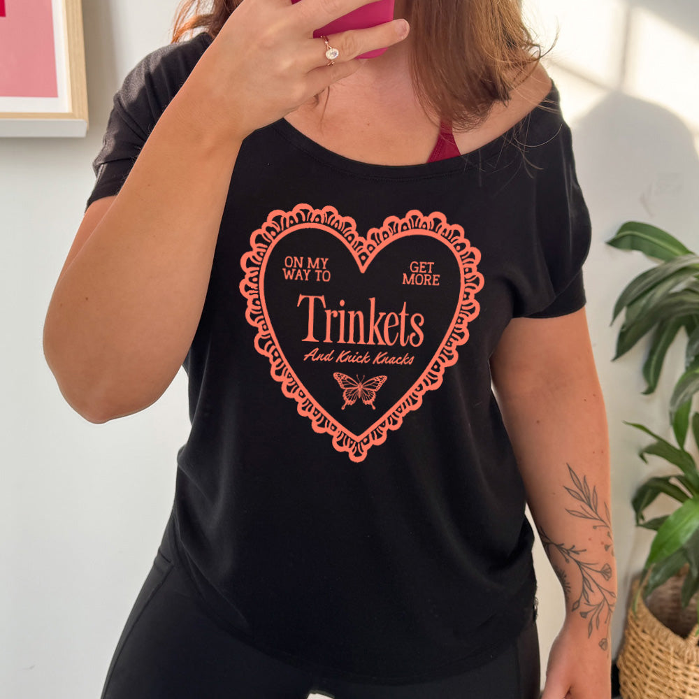 blacky slouchy tee with the graphic of a large heart with a lacy border, and within it the words "on my way to get more trinkets and Knick Knacks" and the graphic of a little butterfly