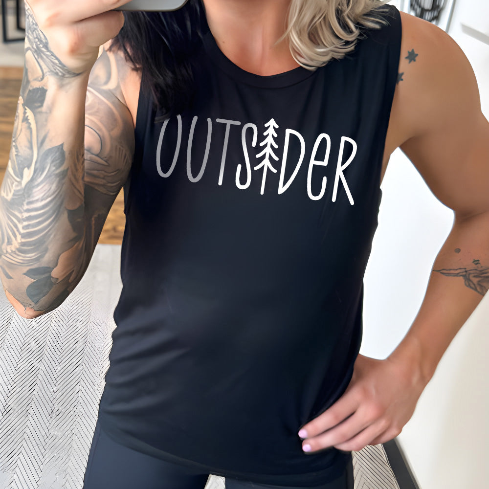 Model wearing black colored muscle tank with a tree graphic on it that says "Outsider"