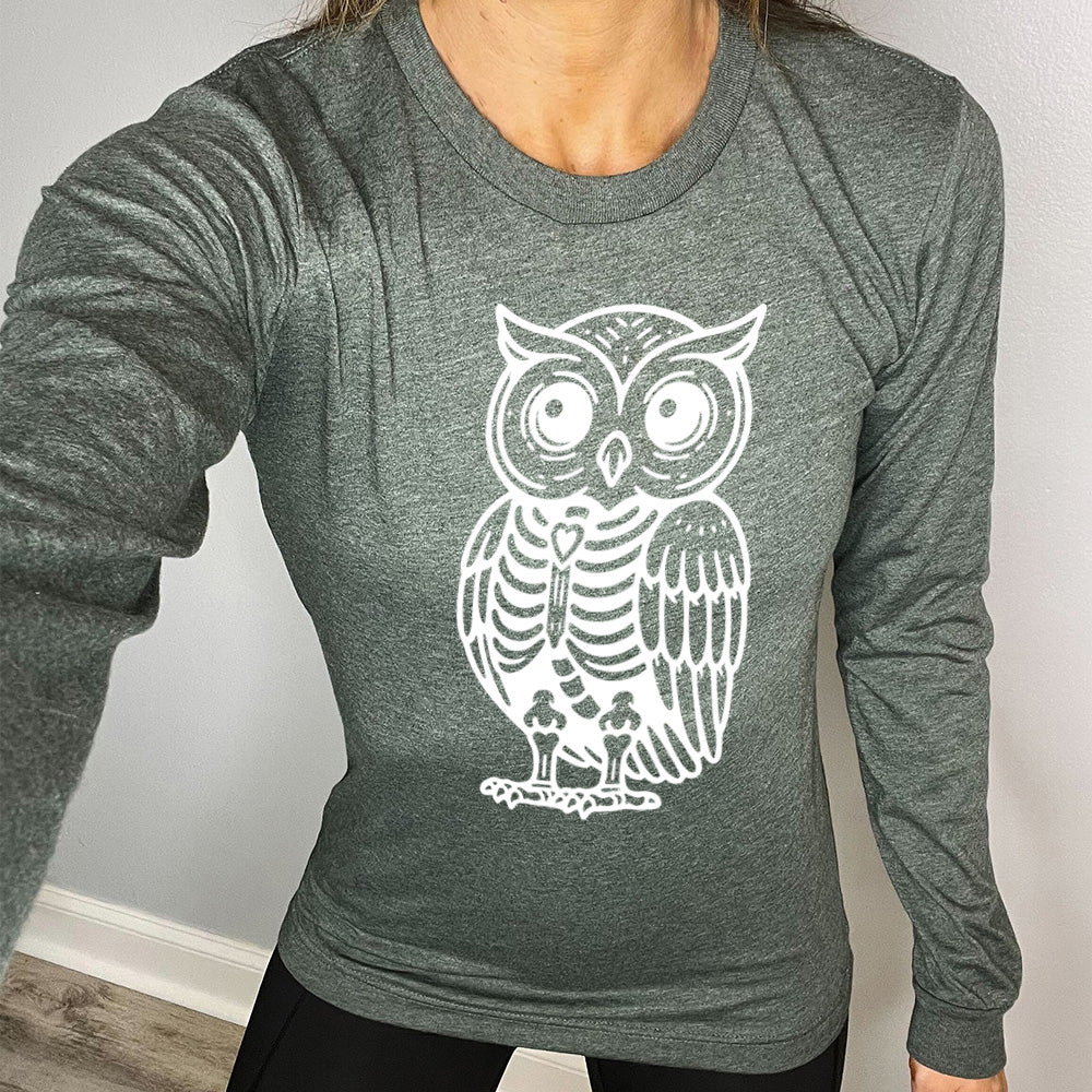 heather forest long sleeve tee with the large graphic of an owl with part of its body in skeletal form, with a little heart in the middle of its ribcage