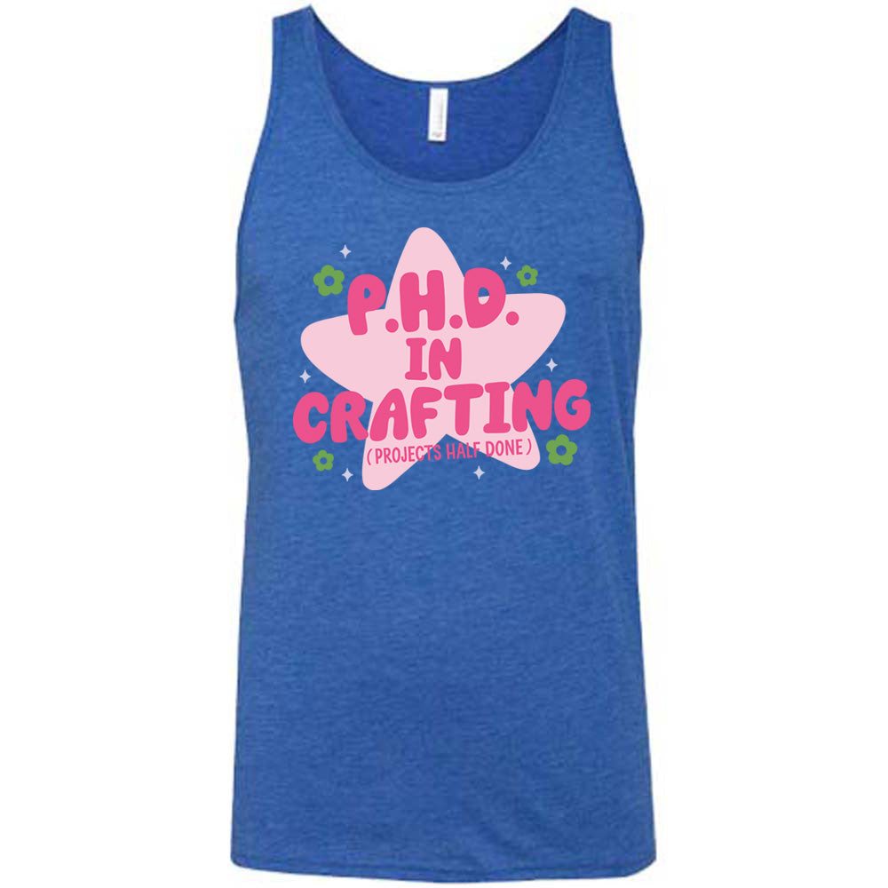 blue unisex tank with cartoon graphic of a large star behind the words "P.H.D.  in Crafting" in large font with the words (Projects Half Done) in small font underneath, with very small flowers and stars around