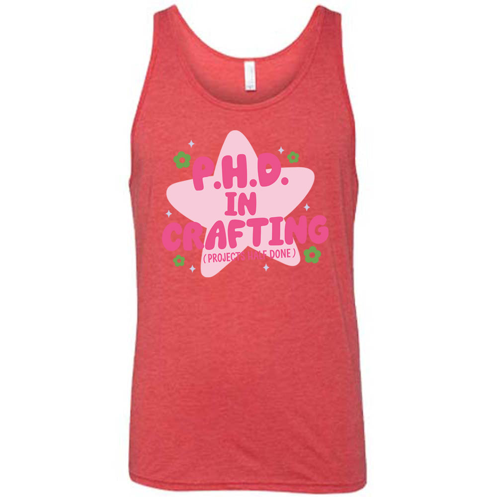 red unisex tank with cartoon graphic of a large star behind the words "P.H.D.  in Crafting" in large font with the words (Projects Half Done) in small font underneath, with very small flowers and stars around