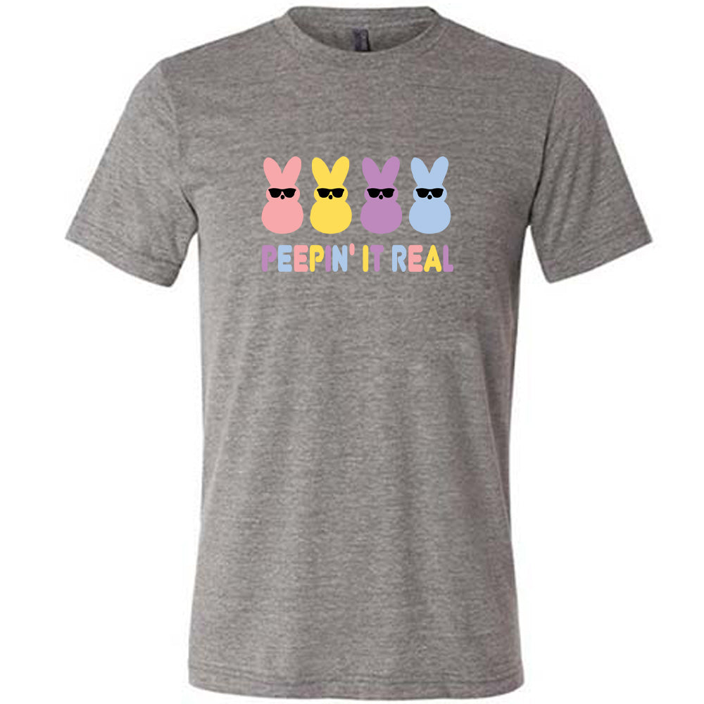 Grey colored shirt with an Easter-colored bunnies graphic on it that says "Peepin it Real" 