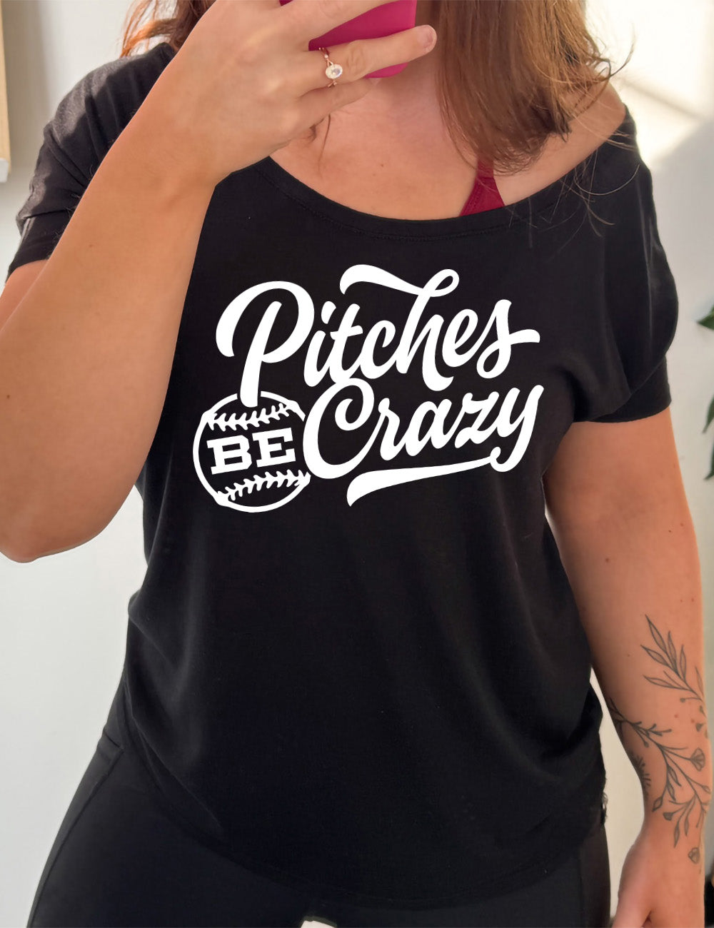 black slouchy tee with the words "pitches be crazy" on it, with the word "be" inside of a baseball outline graphic