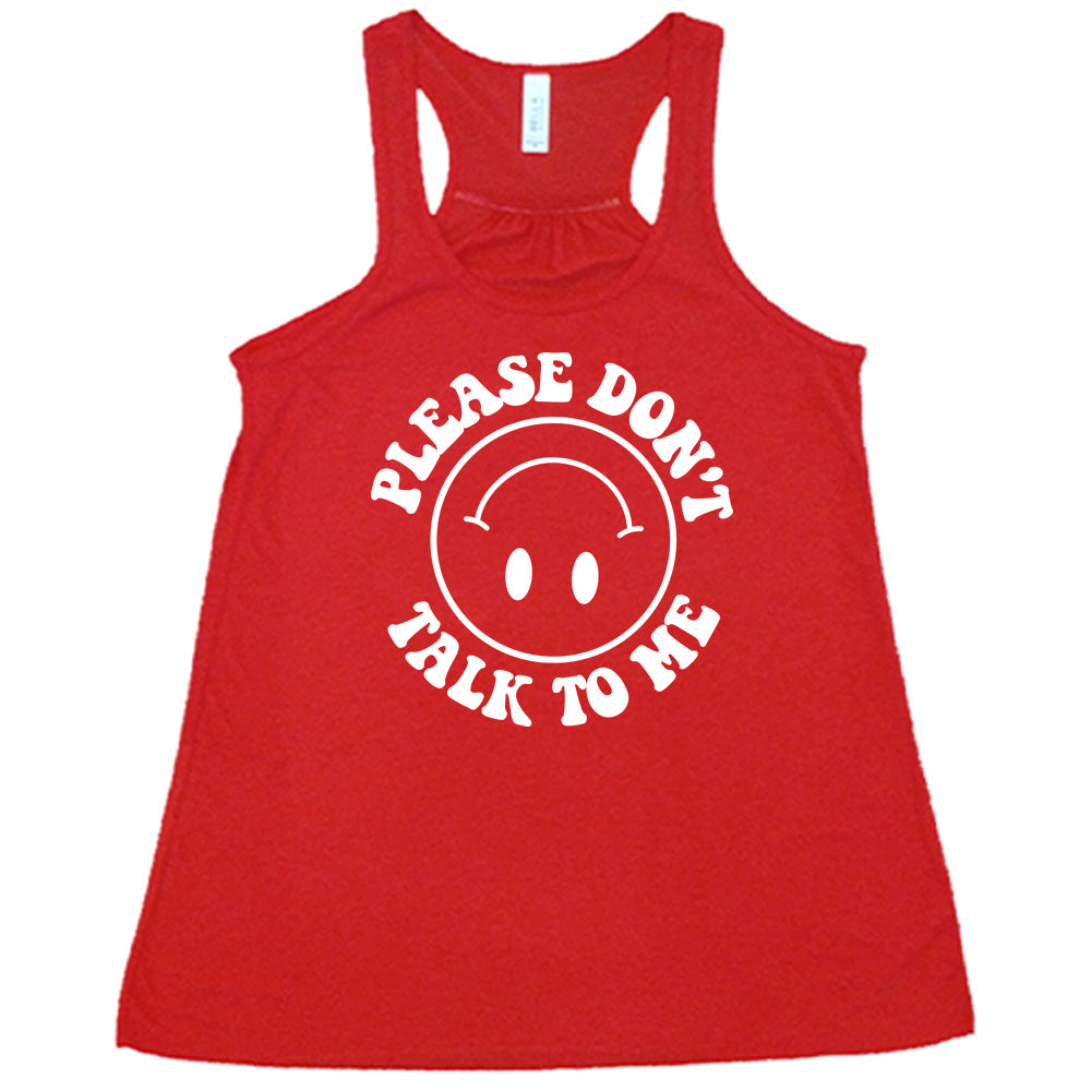 red flowy tank with the words "please don't talk to me" creating mirrored arcs around the outlined circle graphic of an upside-down happy face