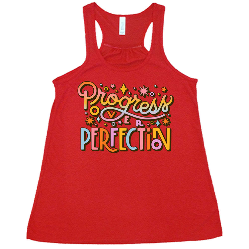 Red flowy tank with Progress Over Perfection written in colorful lettering, with various stars