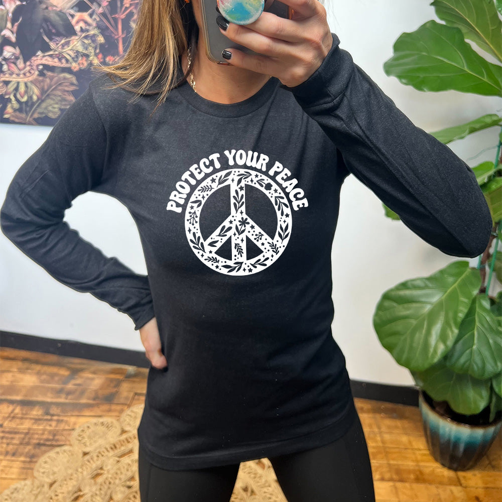black shirt with the text "protect your peace" and a peace sign graphic on it