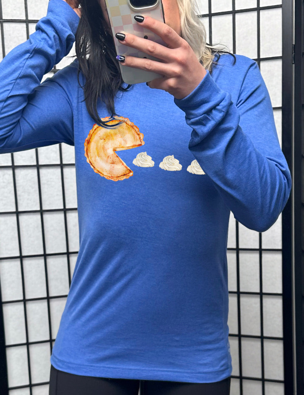 heather true royal long sleeve tee with the graphic of a pumpkin pie, with the a slice taken out of it so that it looks like Pacman, heading in the direction of three dollops of whipped cream