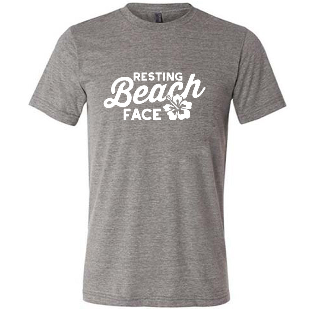 Grey colored shirt with a flower graphic on it that says "Resting Beach Face" 