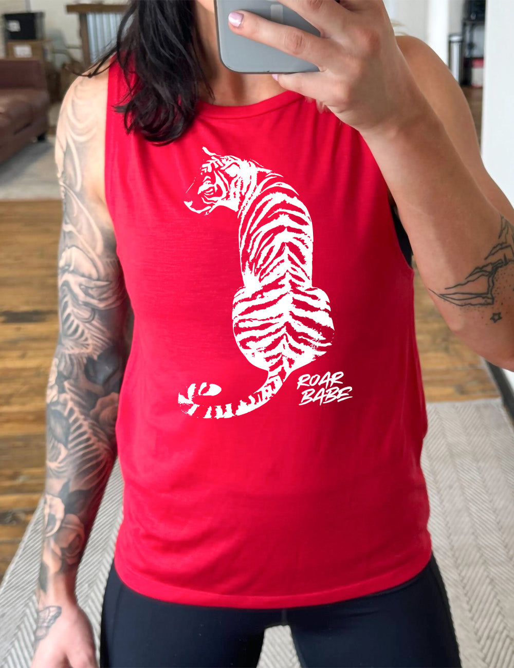 red muscle tank with the graphic of a tiger, from the back, sitting, looking to one side, with the words "roar babe" in small font underneath