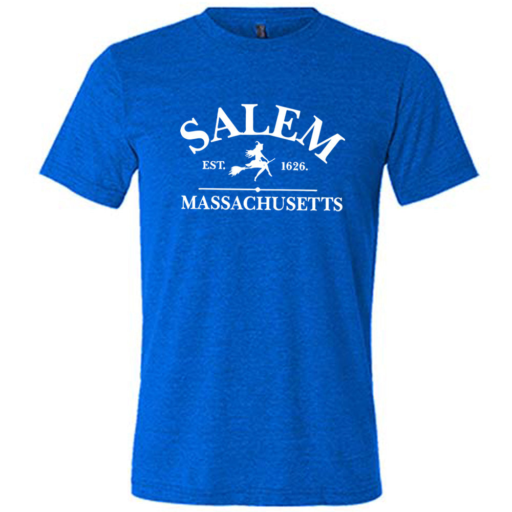 Blue colored shirt with witch on a broom graphic on it that says "Salem EST. 1626 Massachusetts"