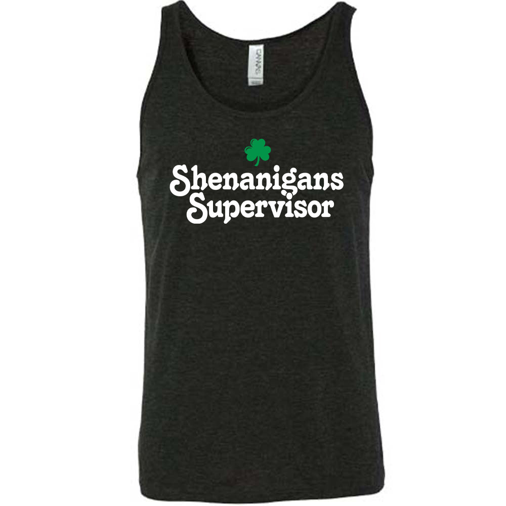 black unisex tank with the words "shenanigans supervisor" on it, with one small clover graphic above it