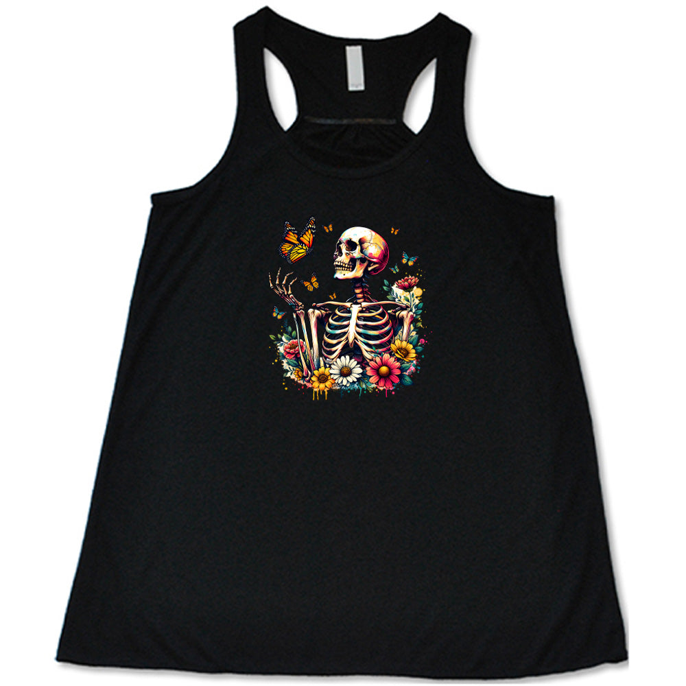 Black colored flowy tank with a skeleton, butterflies, and flowers graphic on it