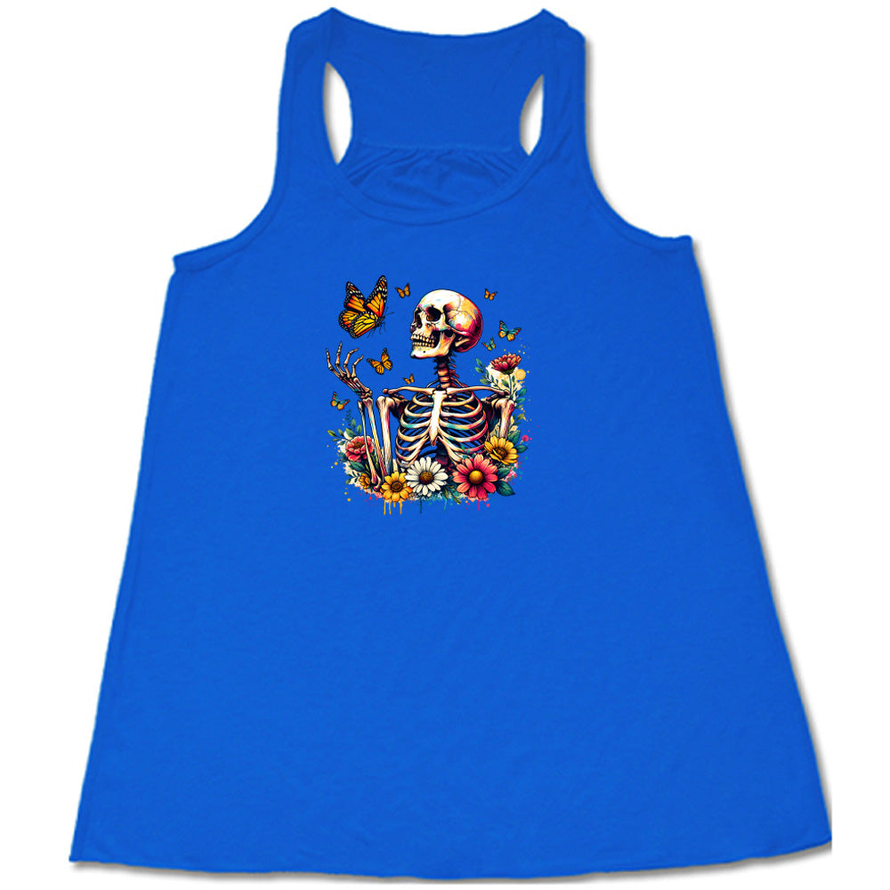 Blue colored flowy tank with a skeleton, butterflies, and flowers graphic on it