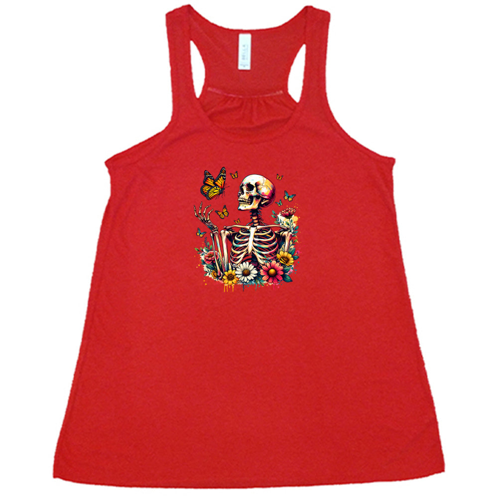 Red colored flowy tank with a skeleton, butterflies, and flowers graphic on it