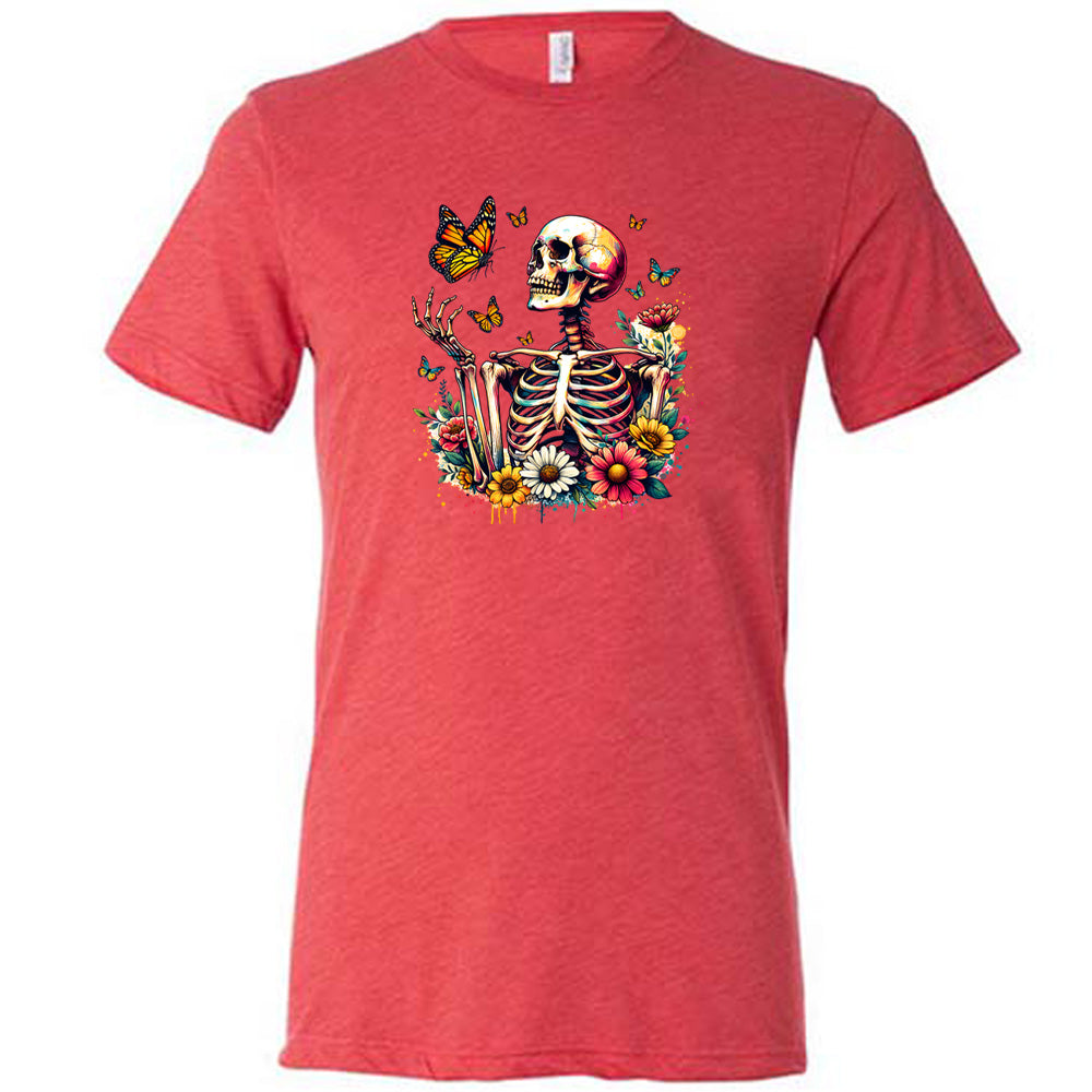 Red colored shirt with a skeleton, butterflies, and flowers graphic on it