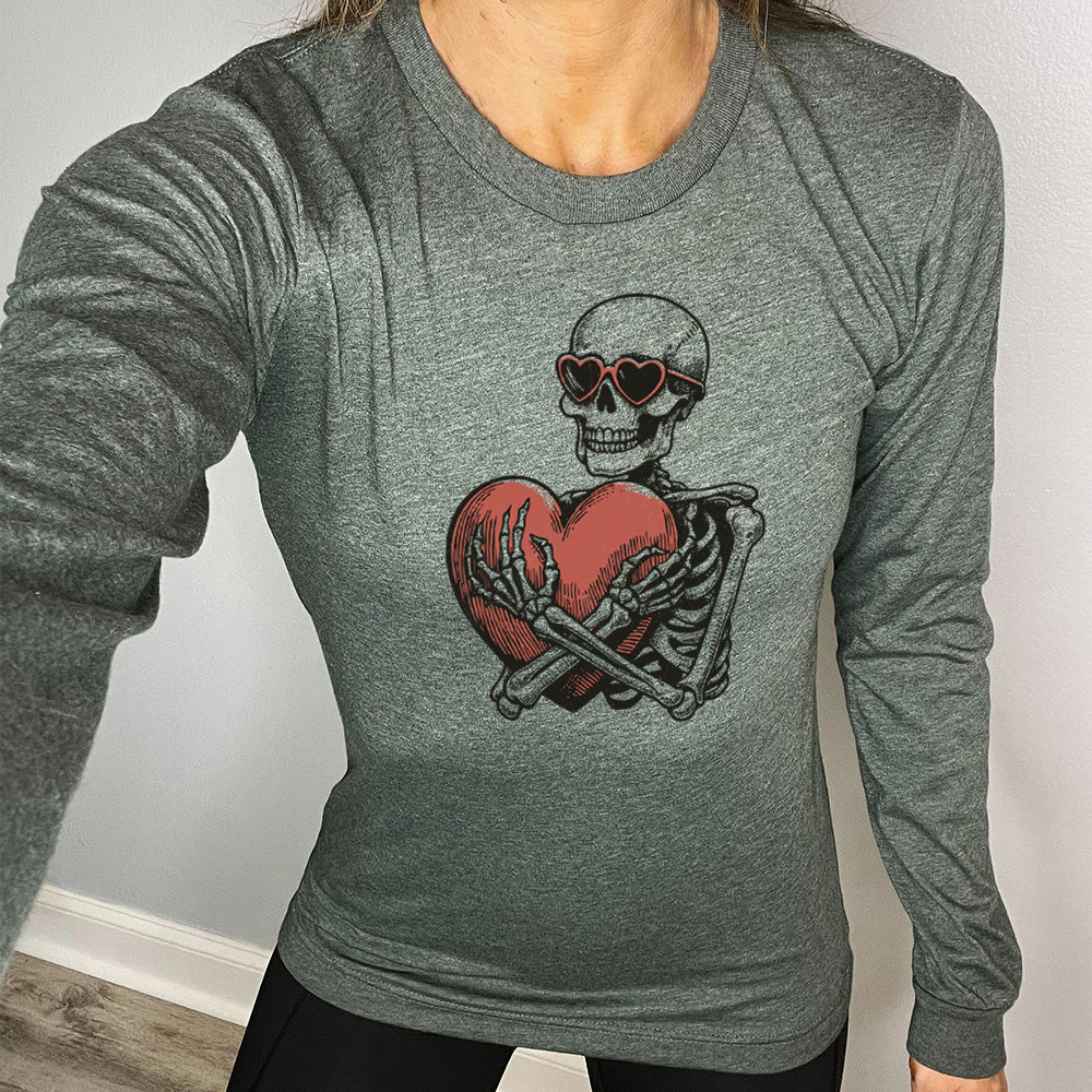 heather forest long sleeve shirt with the graphic of a skeleton, wearing sunglasses, hugging a big heart close