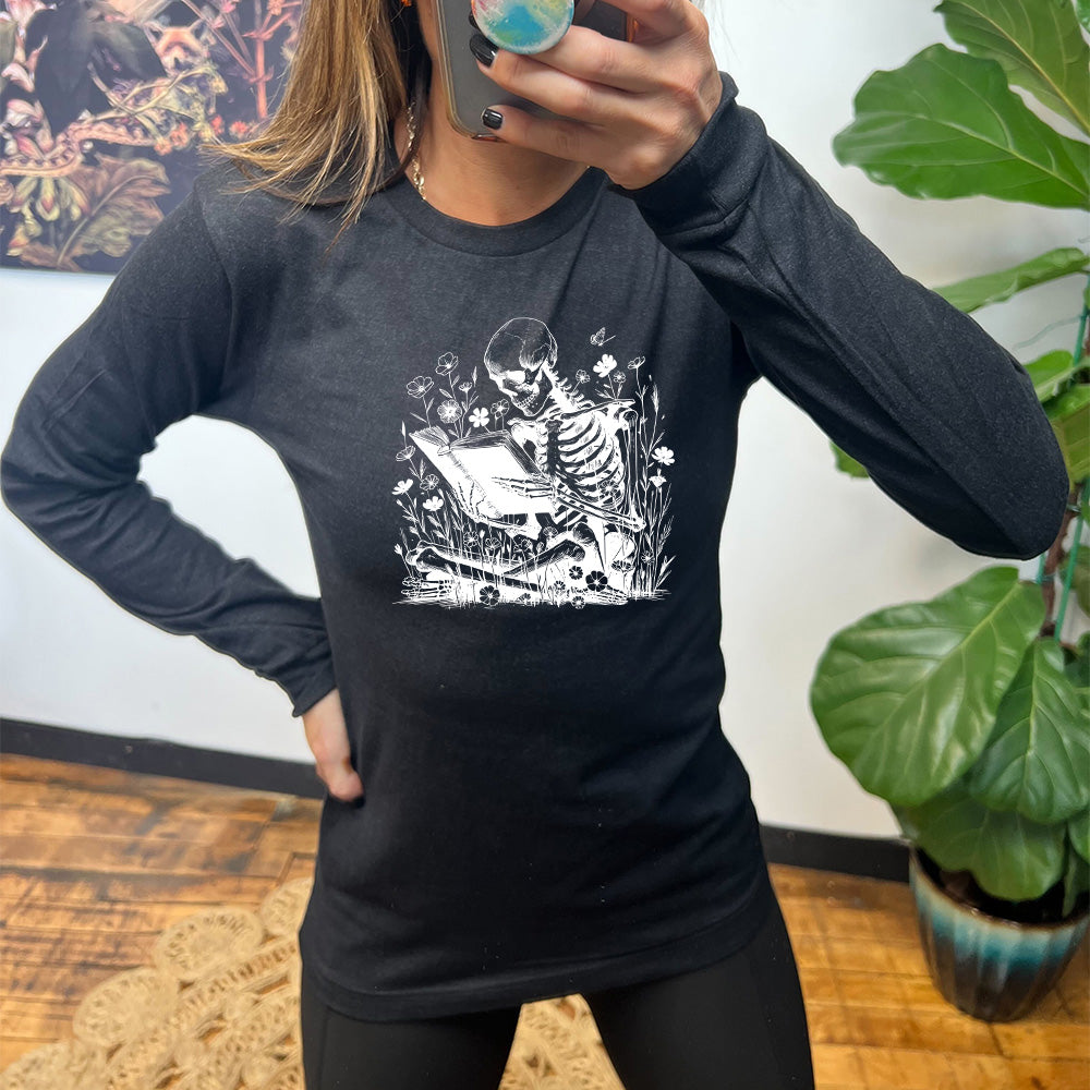 black shirt with a skeleton reading graphic on it
