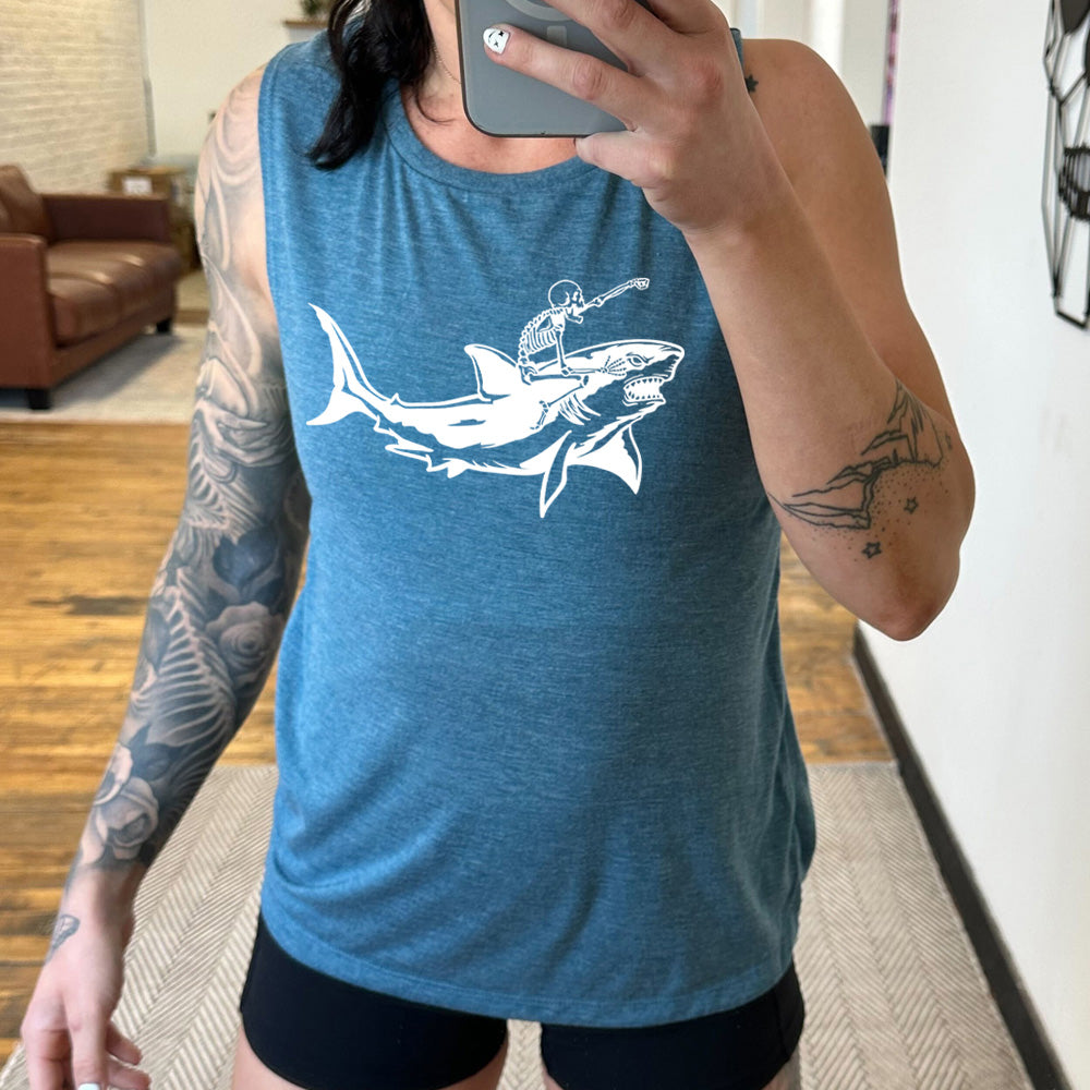 deep teal muscle tank with the graphic of a skeleton, with its fist pointing onwards and its mouth open, riding a shark, who has a fierce expression