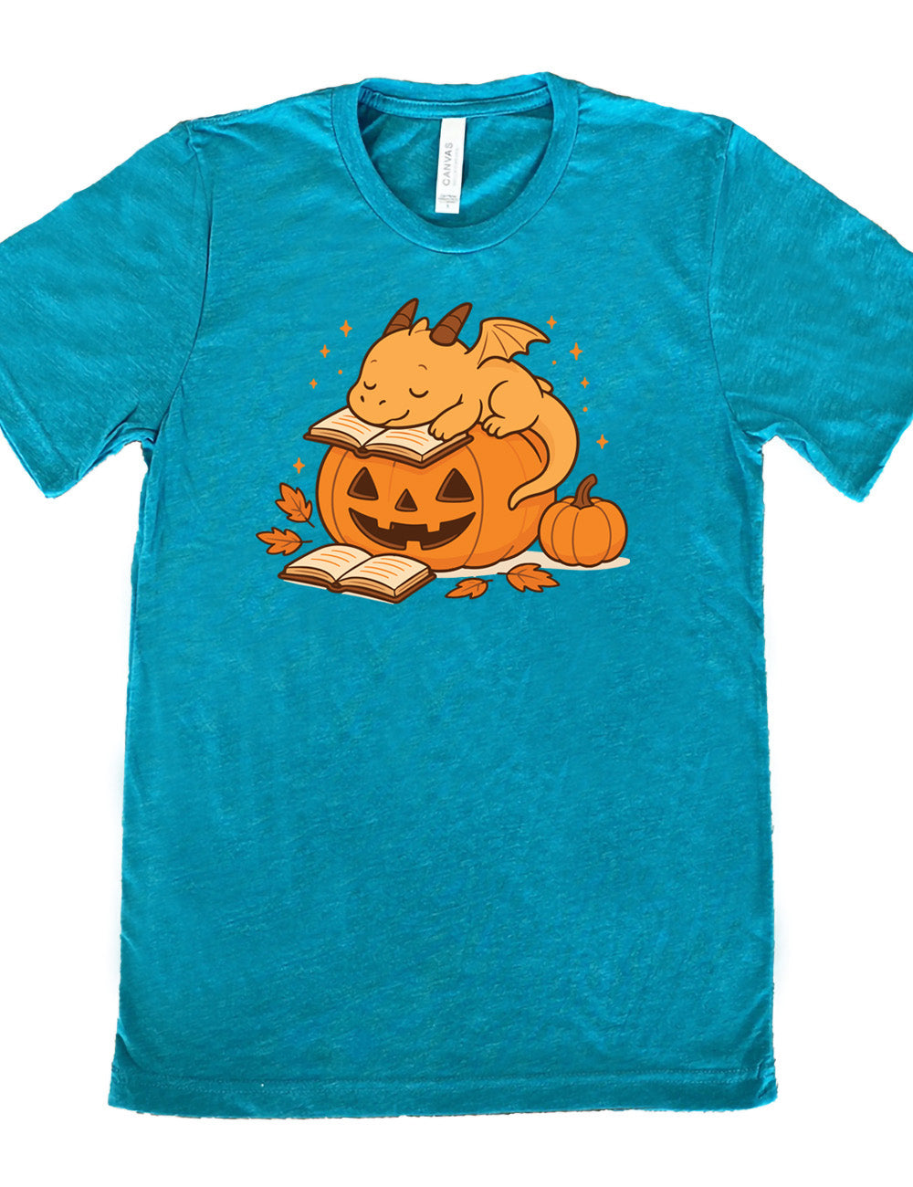 teal unisex tee with the graphic of a cartoon-style dragon sleeping, with its head in its open book, on top of a jack-o-lantern, with another open book and small pumpkin next to all this, and a scattering of stars, and a few leaves