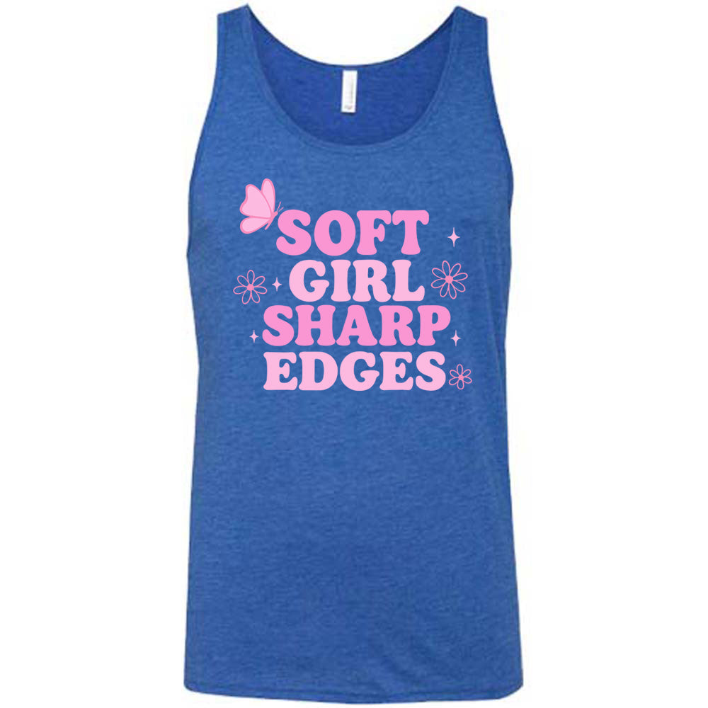blue unisex tank with the words "soft girl sharp edges" in all caps, with graphics of a few little flowers and stars and one butterfly 