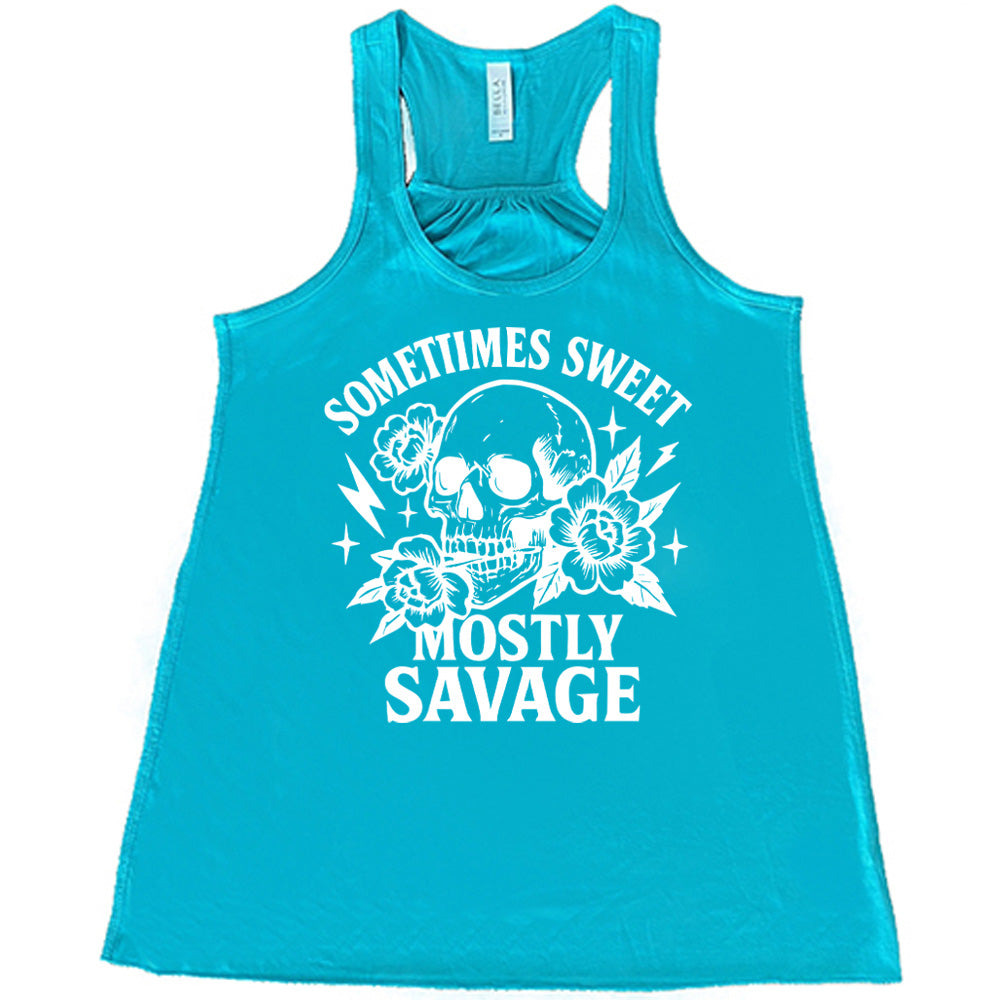 teal flowy tank with the words "sometimes sweet mostly savage on it with the graphic of a skull holding a flower between its teeth, with a couple flowers and a few stars and lightening bolts around it