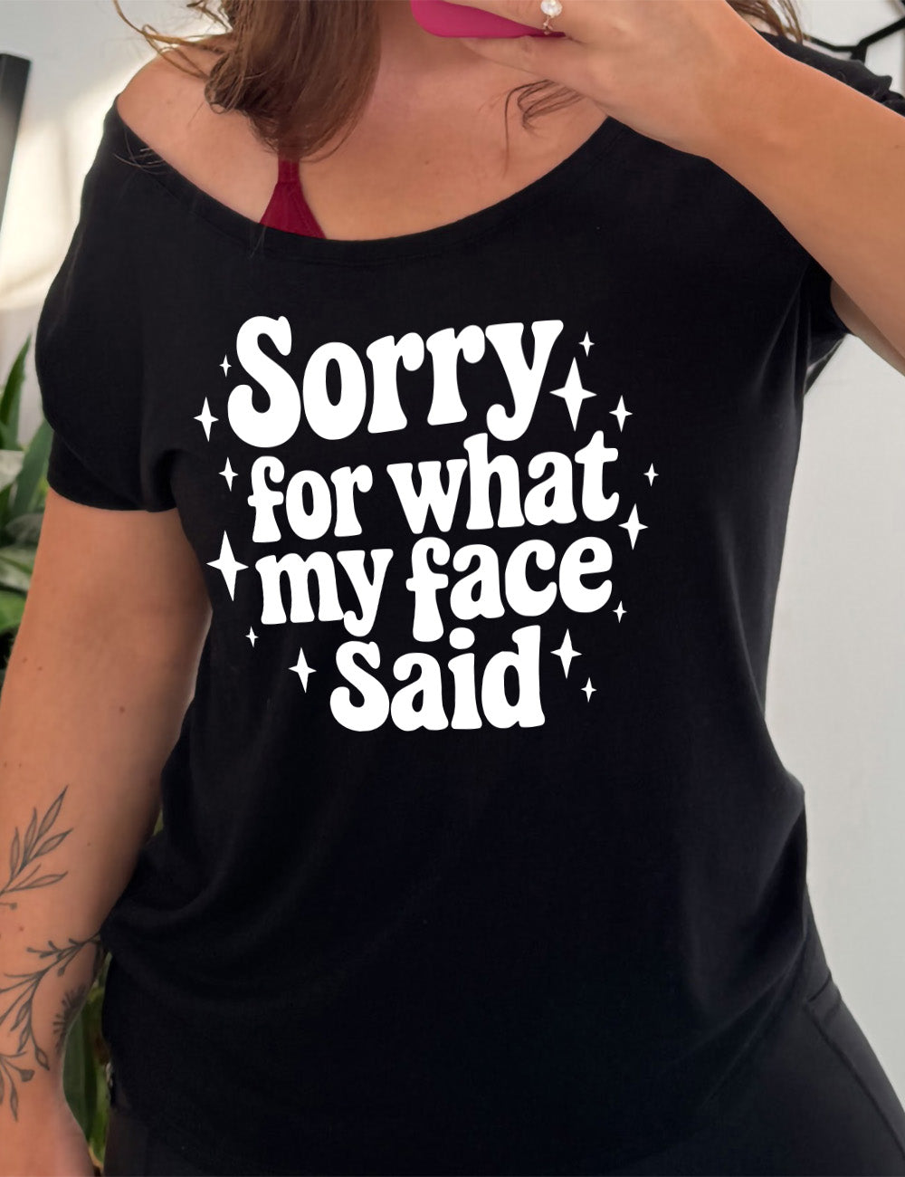 black slouchy tee with the words, surrounded by stars, saying " sorry for what my face said" 